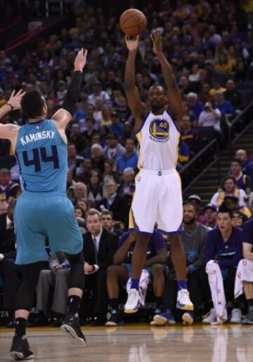 Frank Kaminsky III intenta bloquear el lanzamiento a Harrison Barnes.