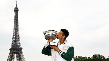 Novak Djokovic besa la Copa de los Mosqueteros en París, con la Torre Eiffel al fondo.