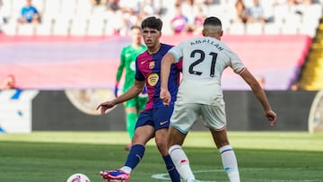 El defensa del Barcelona Pau Cubarsí (i) pelea un balón con el centrocampista belga del Valladolid Selim Amallah.