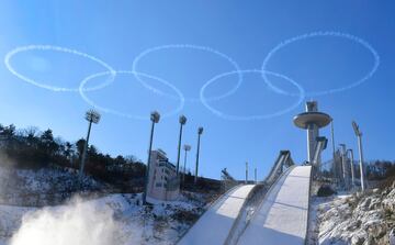 Miembros del ejército del aire de Corea del Sur hacen el logo olímpico con los 5 aros en el cielo encima de la plataforma de saltos que se usará en los Juegos Olímpicos de invierno en Pyeongchang