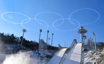 Miembros del ej¨¦rcito del aire de Corea del Sur hacen el logo ol¨ªmpico con los 5 aros en el cielo encima de la plataforma de saltos que se usar¨¢ en los Juegos Ol¨ªmpicos de invierno en Pyeongchang