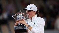 Iga Swiatek bites the trophy after beating Coco Gauff in the final at the French Open.