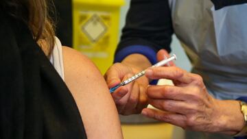 05 December 2021, United Kingdom, London: A health worker administers a dose of Pfizer/BioNTech COVID-19 booster vaccine to a woman. People are urged to get a COVID-19 booster jab to limit the spread of the Omicron variant. Photo: Dinendra Haria/SOPA Imag