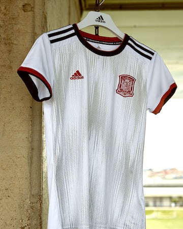 La segunda equipación de España se trata de una camiseta blanca, con diseño frontal y cuello redondo con detalles en rojo y azul marino. Ha sido también diseñada por las jugadoras durante los distintos encuentros que se han desarrollado con Adidas y los responsables de la RFEF.