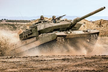 El carro de combate Leopardo 2E es un vehculo de origen alemn, dise?ado por Krauss Maffei Wegmann y fabricado en Espa?a. Este potente tanque tiene una tripulacin de 4 hombres y un peso en orden de combate de 62 toneladas. Sus dimensiones son 9,67 metros de longitud y 3,75 metros de ancho. El Leopardo 2E puede alcanzar una velocidad mxima de 70 km/h y tiene una autonoma de 340 km. Su armamento incluye un ca?n de 120 mm, complementado por dos ametralladoras de 7,62 mm, con capacidad para almacenar hasta 42 disparos. Este carro de combate es conocido por su robustez, movilidad y capacidad de fuego, lo que lo convierte en un elemento esencial en las operaciones militares modernas.
