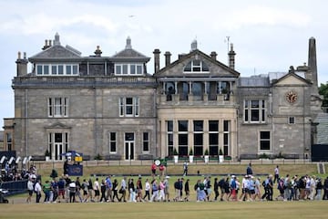 Spectators walk across the course in front of the clubhouse during practice for The 150th British Open Golf Championship