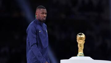 LUSAIL CITY, QATAR - DECEMBER 18: Marcus Thuram of France walks past the FIFA World Cup Qatar 2022 Winner's Trophy during the awards ceremony after the FIFA World Cup Qatar 2022 Final match between Argentina and France at Lusail Stadium on December 18, 2022 in Lusail City, Qatar. (Photo by Clive Brunskill/Getty Images)