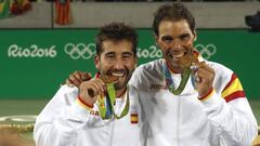 Marc López y Rafa Nadal muerden la medalla de oro lograda en la modalidad de dobles en los Juegos Olímpicos de Río.