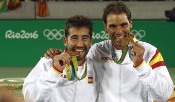 Marc López y Rafa Nadal muerden la medalla de oro lograda en la modalidad de dobles en los Juegos Olímpicos de Río.