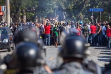 Miembros de la Policía brasileña dispersan a un grupo de manifestantes, durante la primera protesta contra el Mundial de fútbol Brasil 2014 registrada en Sao Paulo (Brasil), en el día en que comienza la competición. Cerca de 150 hombres de la Tropa de Choque de la Policía Militarizada del estado de Sao Paulo dispersaron a un grupo de 50 manifestantes que intentaba marchar por la avenida Radial Este, la principal vía de acceso al Arena Corinthians, el estadio de Sao Paulo en que se disputará el partido inaugural del Mundial.