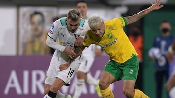 Ecuador's Liga de Quito Argentine Ezequiel Piovi (L) and Argentina's Defensa y Justicia Walter Bou vie for the ball during their Copa Sudamericana group stage football match at the Norberto Tito Tomaghello stadium, in Florencio Varela, Buenos Aires Province, on April 28, 2022. (Photo by Juan MABROMATA / AFP)