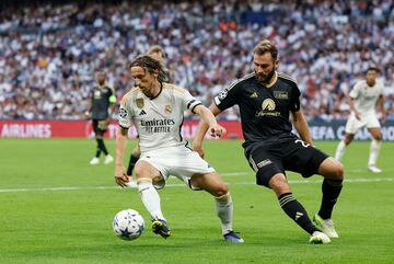 Modric  se lleva el balón ante un contrario.