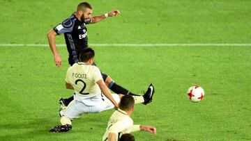Real Madrid's forward Karim Benzema (top) scores a goal as he battles with Club America's defender Paolo Goltz (#2) during the Club World Cup semi-final football match between Club America of Mexico and Real Madrid of Spain at Yokohama International stadium in Yokohama on December 15, 2016. / AFP PHOTO / TORU YAMANAKA
