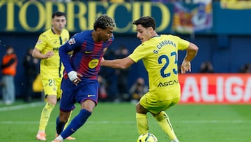 VILLARREAL (CASTELLÓN), 21/12/2025.- El defensa del Villarreal Sergi Cardona (d) pelea un balón ante el delantero del Barça Lamine Yamal este domingo, durante el partido de la jornada 17 de LaLiga EA Sports, que disputan Villarreal CF y el FC Barcelona en el Estadio de la Cerámica. EFE/ Ana Escobar