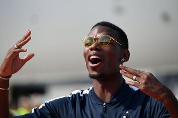 France's midfielder Paul Pogba celebrates with teammates after disembarking from the plane upon their arrival at the Roissy-Charles de Gaulle airport on the outskirts of Paris, on July 16, 2018 after winning the Russia 2018 World Cup final football match.