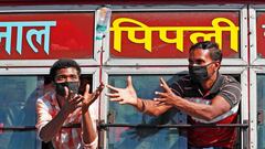 Migrant workers, who are returning to their villages, try to catch a water bottle distributed by the local residents, on a highway during a 21-day nationwide lockdown to limit the spreading of coronavirus disease (COVID-19), in Ghaziabad, on the outskirts