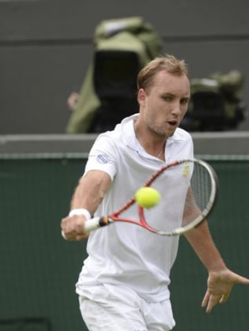 El tenista belga Steve Darcis devuelve una bola al español Rafael Nadal, durante el partido de primera ronda del torneo de tenis de Wimbledon