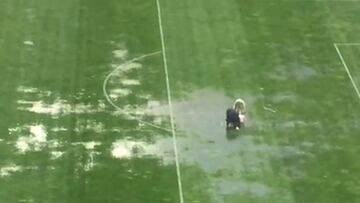 ¡A puro balde! La cancha está llena de pozas y en Bolivia lo solucionan así