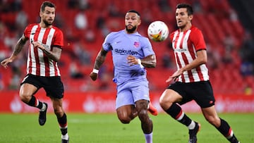 BILBAO, SPAIN - AUGUST 21: Memphis Depay of FC Barcelona runs between Inigo Martinez and Daniel Vivian of Athletic Bilbao during the LaLiga Santander match between Athletic Club and FC Barcelona at San Mames Stadium on August 21, 2021 in Bilbao, Spain. (P