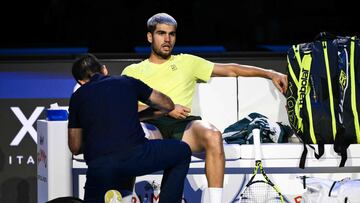 Spain's Carlos Alcaraz receives medical treatment during the men's single final match against Italy's Jannik Sinner at the ATP Finals tennis tournament, in Turin, on November 16, 2025. (Photo by Marco BERTORELLO / AFP)