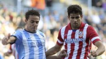 Weligton, defensa del Málaga, trata de robar el balón a Diego Costa, delantero rojiblanco.