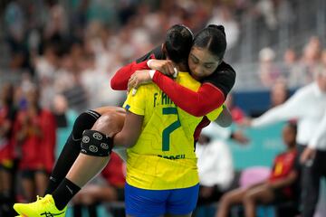 La jugadora de Brasil Tamires Araujo saca en brazos a la jugadora de Angola Albertina Kassoma después de lesionarse en un partido de balonmano femenino.