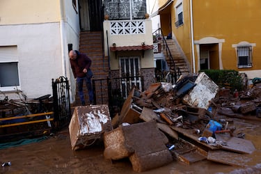 Un hombre observa los restos de las pertenencias de la gente tras las inundaciones en Utiel, España.