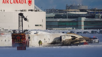 An emergency responder works around an aircraft on a runway, after a plane crash at Toronto Pearson International Airport in Mississauga, Ontario, Canada February 17, 2025. REUTERS/Cole Burston