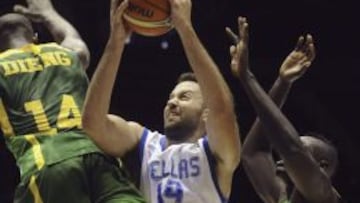 El pivot de la selecci&oacute;n de Grecia Ian Vougioukas (c) entra a canasta ante el pivot de Senegal Gorgui Dieng (i), en el partido correspondiente a la primera jornada de la Copa del Mundo de Baloncesto, Grupo D, disputado en el Palacio de los Deportes San Pablo de Sevilla.