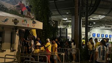 Fans use barricades as ladders to climb into the Hard Rock Stadium for the Copa America Finals between Argentina and Colombia in Miami Gardens, Florida, U.S., July 14, 2024. REUTERS/Maria Alejandra Cardona