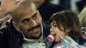 El jugador del Manchester United Juan Sebastián Verón saluda acompañado de su hija.