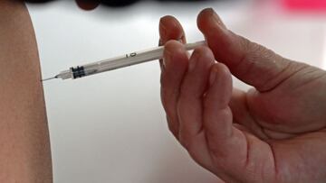 A woman is inoculated with the Russian Sputnik V vaccine against COVID-19, at the Lanus National University in Buenos Aires, on May 23, 2021. (Photo by ALEJANDRO PAGNI / AFP)