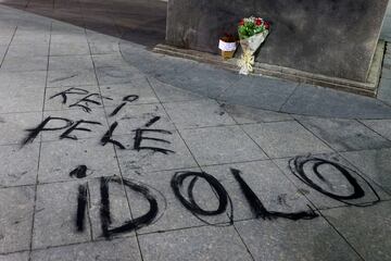 Un ramo de flores y una pintada a los pies de la estatua de Pelé, delante del estadio de Maracana, en Río de Janeiro.