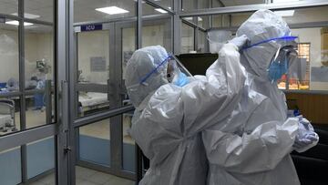 A member of the medical staff helps a colleague adjust her protective gear, as they prepare to enter the Intensive Care Unit (ICU) to tend to patients affected by the COVID-19, caused by the novel coronavirus, at the Machakos County Level-5 hospital in Machakos on July 28, 2020. - Kenyan President on July 27, 2020 banned the sale of alcohol in restaurants after noting an "aggressive surge" in COVID-19 cases among young people who were socialising "particularly in environments serving alcohol". (Photo by Simon MAINA / AFP)