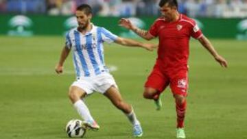 Medel, jugador del Sevilla, trata de robarle el balón a Isco.