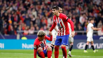 Morata ayuda a Griezmann a levantarse en el partido contra el Sevilla.