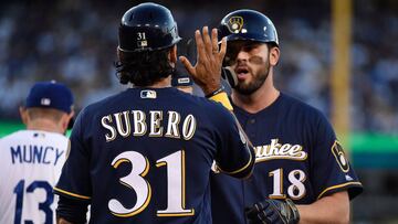 LOS ANGELES, CA - OCTOBER 15: Mike Moustakas #18 of the Milwaukee Brewers gets a high-five from first base coach Carlos Subero #31 after Moustakas singled to center field during the fourth inning of Game Three of the National League Championship Series ag