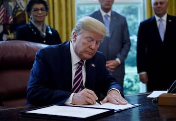 US President Donald Trump signs the Paycheck Protection Program and Health Care Enhancement Act in the Oval Office of the White House in Washington, DC, on April 24, 2020. - The $483 billion stimulus act will back small businesses on the brink of bankrupt