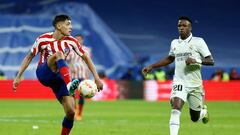 El defensa argentino del Atlético de Madrid Nahuel Molina controla un balón ante el delantero brasileño del Real Madrid Vinícius Júnior, durante el partido que enfrentó este jueves, en el estadio Santiago Bernabéu, al Real Madrid y al Atlético de Madrid en cuartos de final de la Copa del Rey.