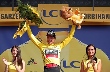 El piloto belga del equipo BMC Racing Team, Greg Van Avermaet celebra en el podio, luciendo la camiseta amarilla de líder.