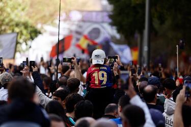 Un niño con la camiseta de Lamine Yamal se levanta ante los miles de aficionados que esperan la llegada de sus equipos antes del partido.