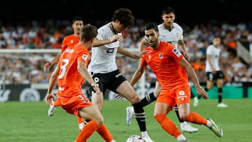 VALENCIA, 27/09/2023.- El centrocampista del Valencia Javi Guerra (c) trata de escapar entre dos jugadores de la Real Sociedad, durante el partido de la séptima jornada de LaLiga EA Sports entre Valencia CF y Real Sociedad, este miércoles en el estadio de Mestalla. EFE/ Biel Aliño