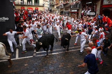 Participantes corren delante de los toros durante el primer encierro de los Sanfermines en Pamplona.