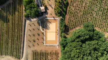 Pista de tenis rodeada de viñedos, olivos y bosques en el dominio vinícola de Blacailloux en Tourves, al sur de Francia.