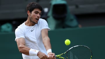 El tenista español Carlos Alcaraz devuelve una bola durante su partido ante Holger Rune en los cuartos de final de Wimbledon.