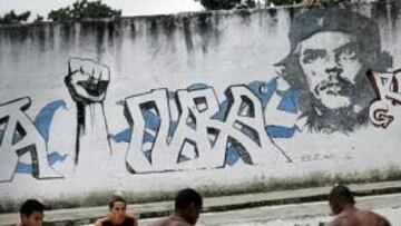 <b>EN LA HABANA. </b>Un grupo de jóvenes juega al fútbol en una calle de La Habana bajo un mural con la figura del Che.
