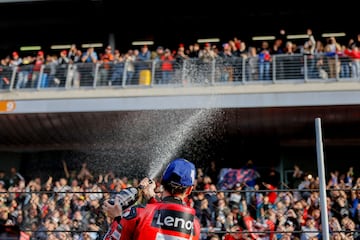 Pecco Bagnaia lanza prosecco al público tras ganar la carrera al esprint del Gran Premio de Barcelona Solidaridad de MotoGP.