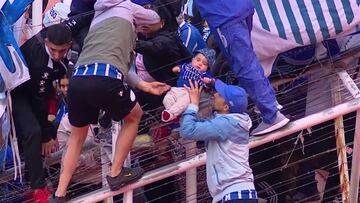 Aficionados de Godoy Cruz sacan a un beb¨¦ de la grada debido a los incidentes provocados por la barra del club.