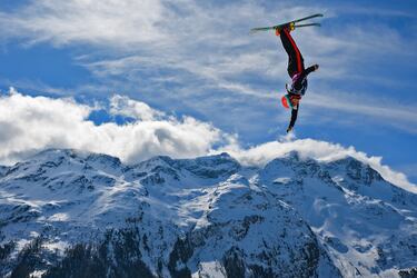 Extraordinaria fotografía que refleja el momento en el que Charlie Fontaine queda boca abajo, como si estuviera haciendo el pino sobre el aire. Se trata de los ejercicios de calentamiento que realiza el canadiense durante las pruebas aéreas mixtas por equipos del Campeonato Mundial de Snowboard, Freestyle y Freeski de la FIS en St Moritz (Suiza).