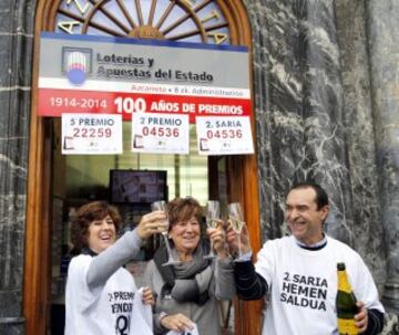 Las loteras Cristina (i) y Asun Azkarreta junto a Ernesto, de la administración Nº 8 de Bilbao, celebran el reparto de dos premios, un quinto, el número 22.259 y un segundo, el 4.536, del sorteo de Navidad del 22 de diciembre. 